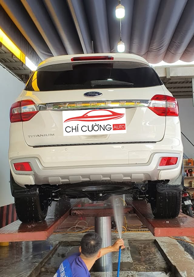 Kỹ thuật viên Chí Cường Auto đang xịt rửa gầm xe Ford Everest từ dưới lên theo đúng quy trình chuyên nghiệp tại Tân Bình TPHCM