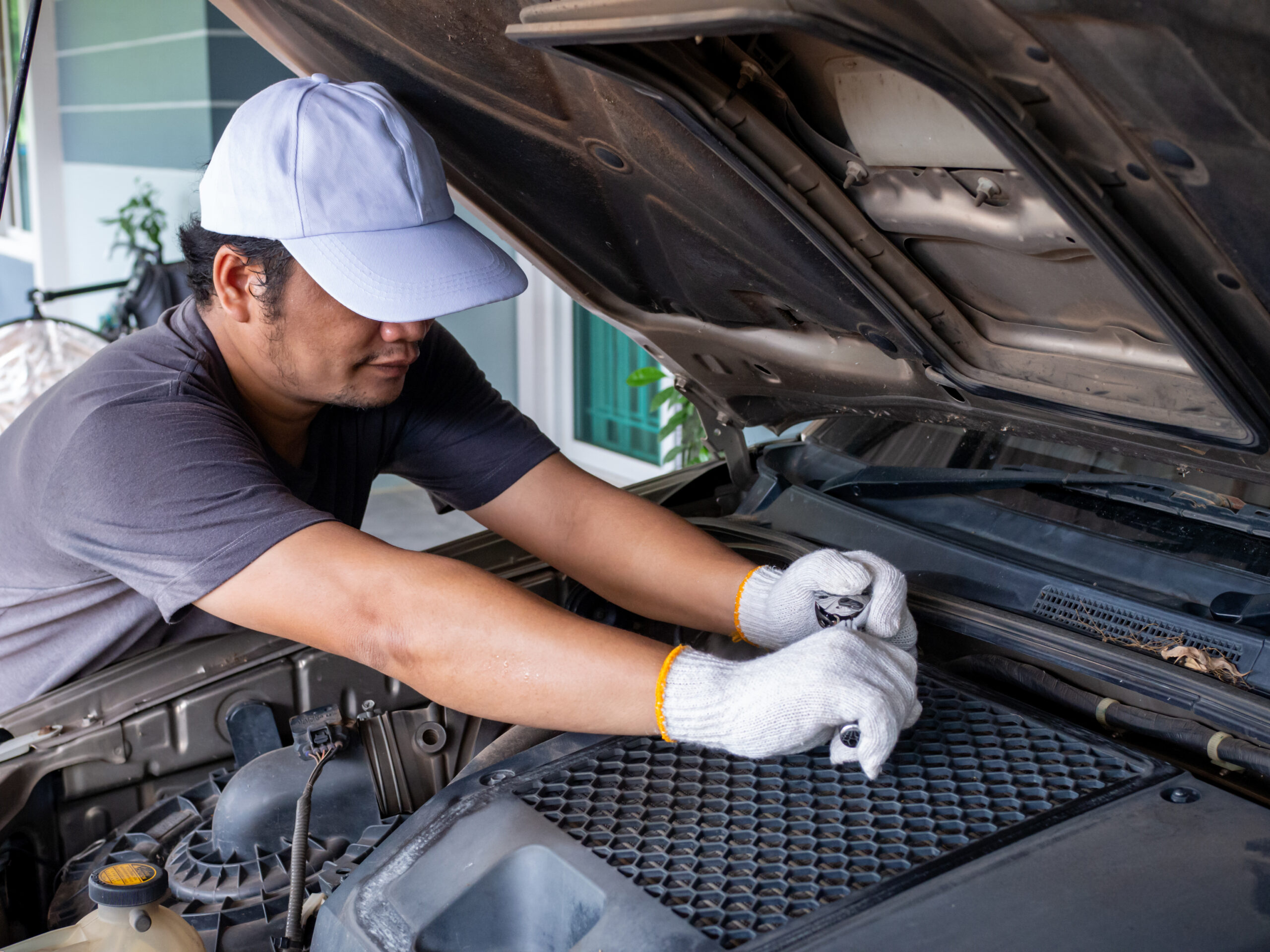 Kỹ thuật viên kiểm tra và vệ sinh hệ thống điều hòa ô tô tại garage