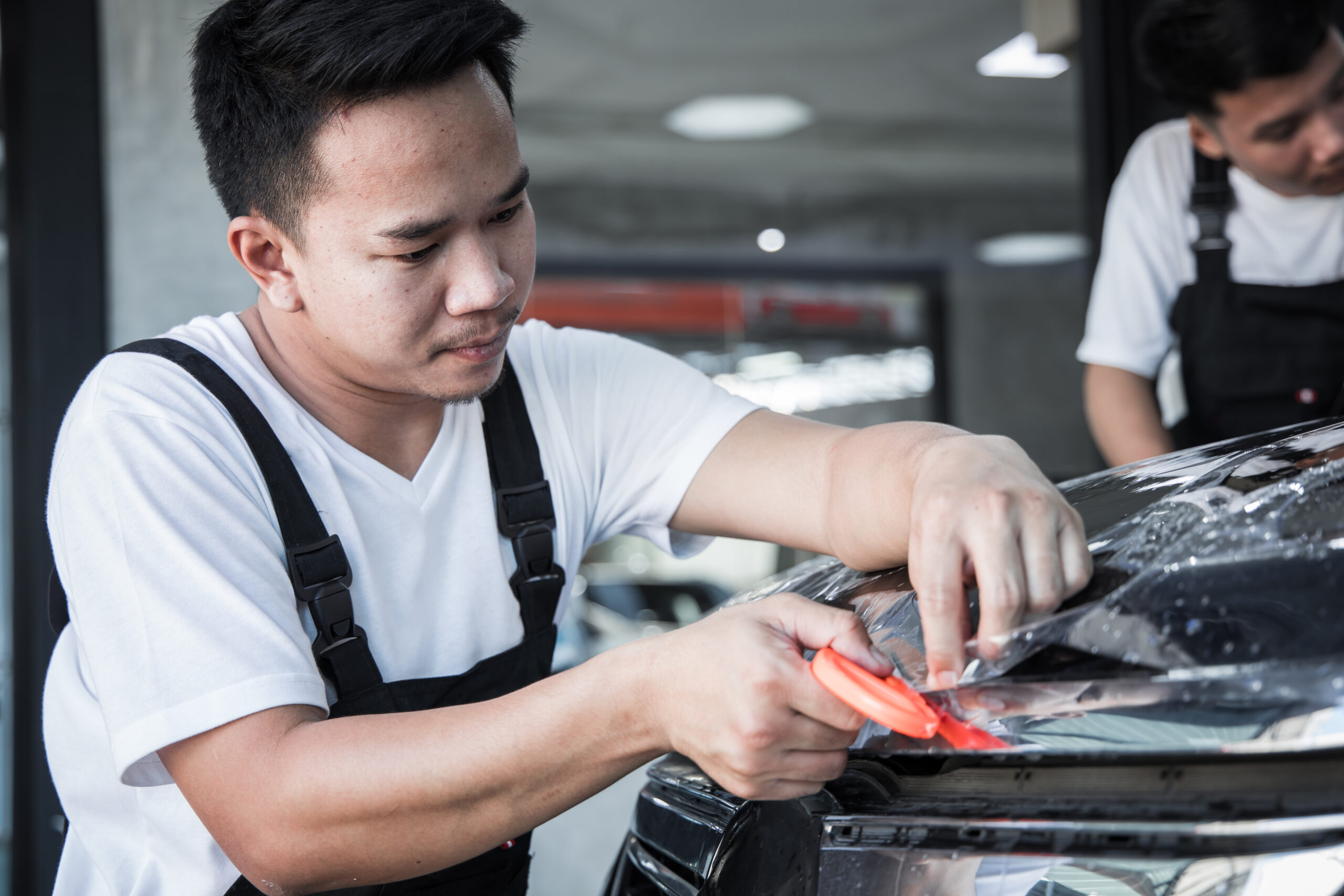 Kỹ thuật viên thi công lớp phủ bảo vệ bề mặt sơn xe tại Chí Cường Auto